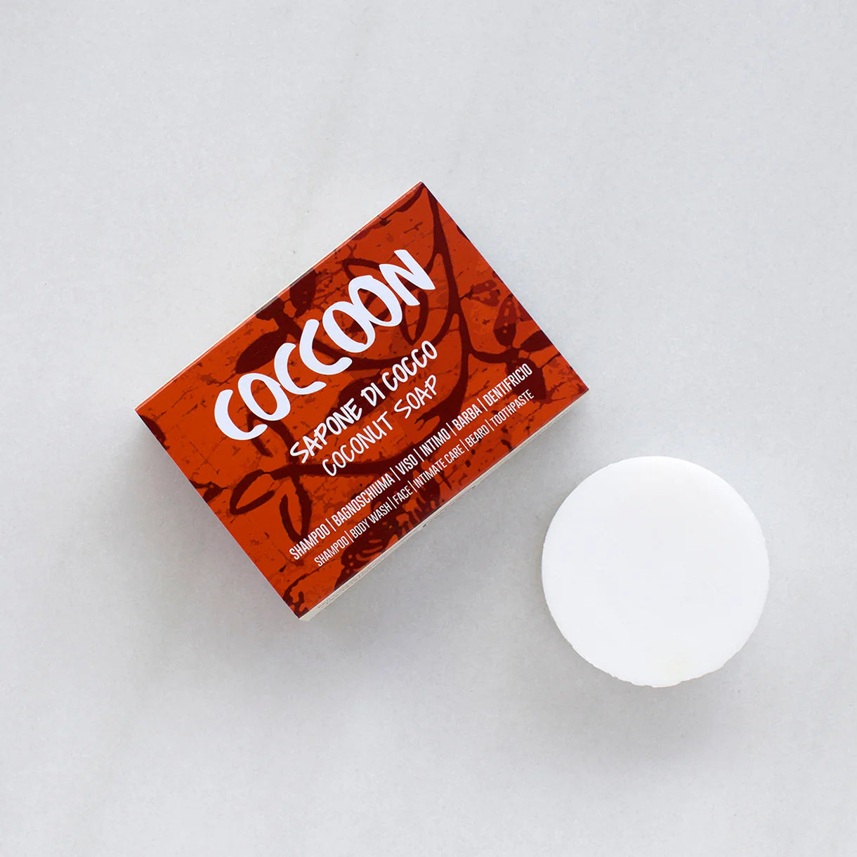 COCCOON: sapone solido di cocco. bianco forma tonda. conferzione in cartone rosso con scritt bianca coccoon sapone di cocco