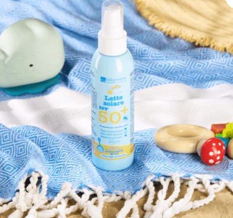 "Latte solare SPF 50+ per bambini in flacone spray azzurro, su telo da spiaggia blu con giocattoli in legno e cappello di paglia"



"Latte solare bambini SPF 50+ spray 150ml - Il Gatto Bio"